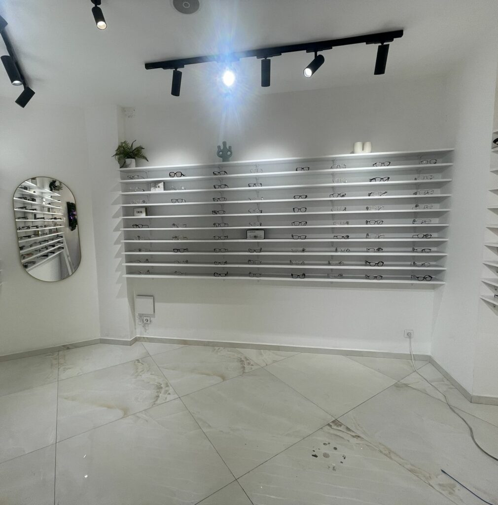 Boutique d’opticien avant travaux à Paris 11e — Espace conseil chaleureux, murs et éclairage repensés