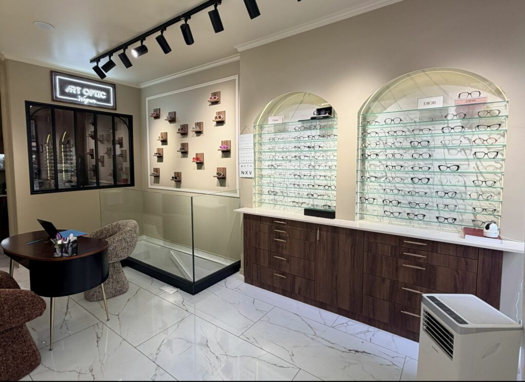Boutique d’opticien après travaux à Paris 17e — Mobilier en bois foncé et sol marbré