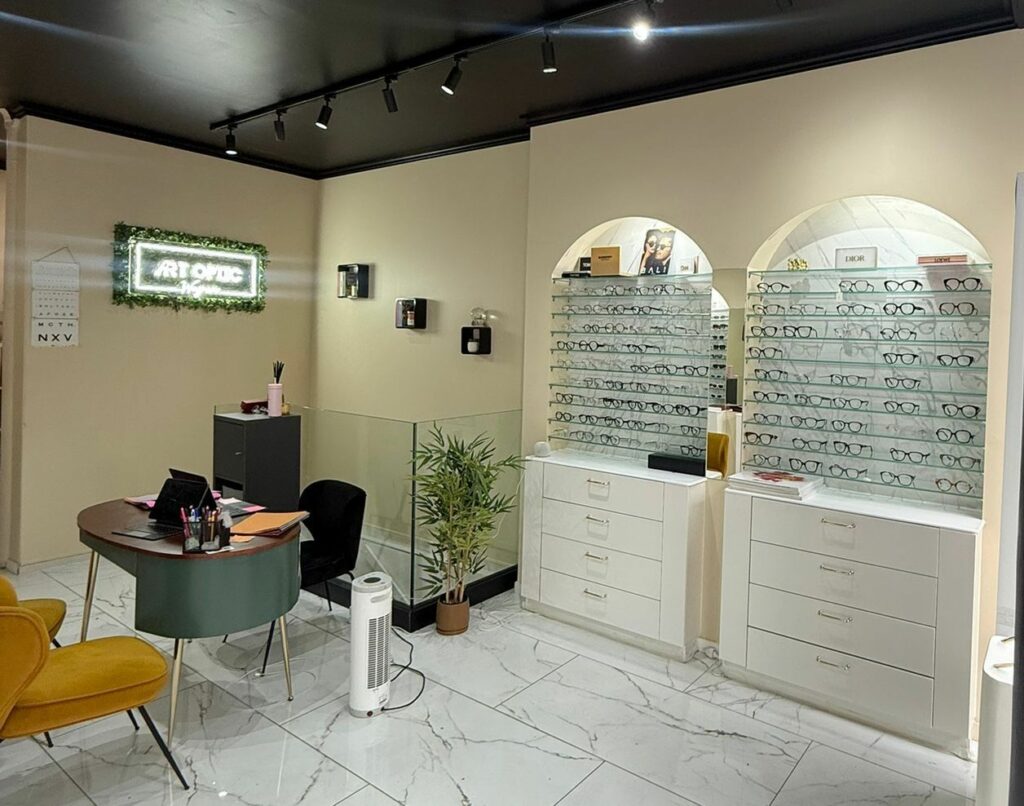 Boutique d’opticien avant travaux à Paris 17e — Mobilier en bois foncé et sol marbré