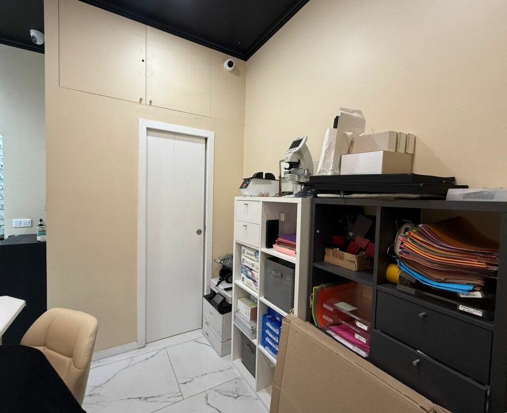 Boutique d’opticien avant travaux à Paris 17e — Arrière-boutique : rangements intégrés du sol au plafond
