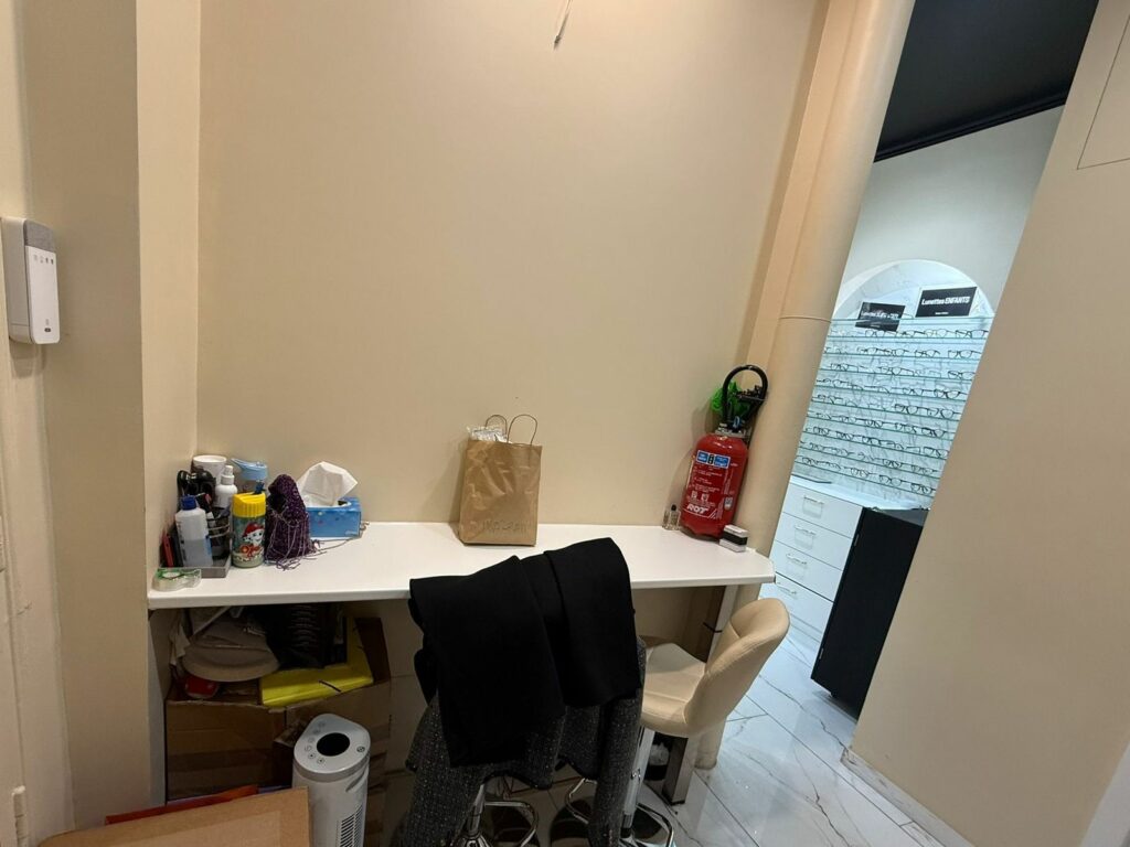 Boutique d’opticien avant travaux à Paris 17e — Atelier avec verrière donnant sur la boutique
