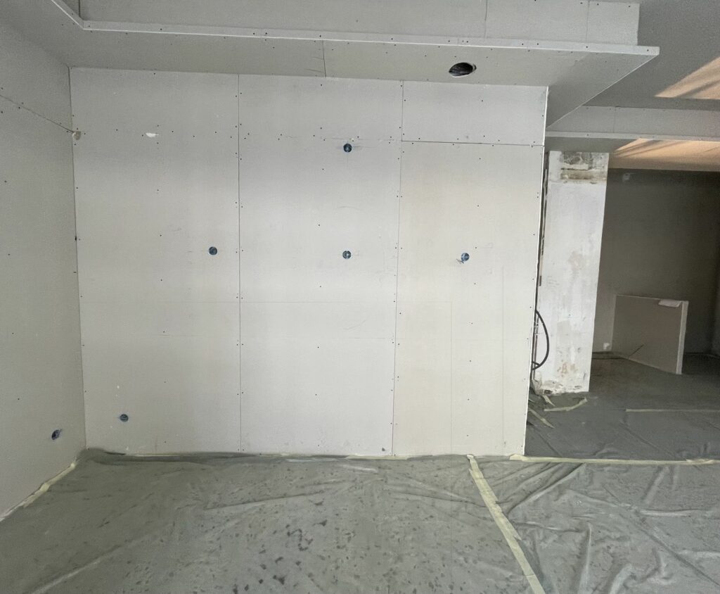 Boutique d’opticien avant travaux à Paris 18e — Mur d'exposition, meubles bas et peinture décorative