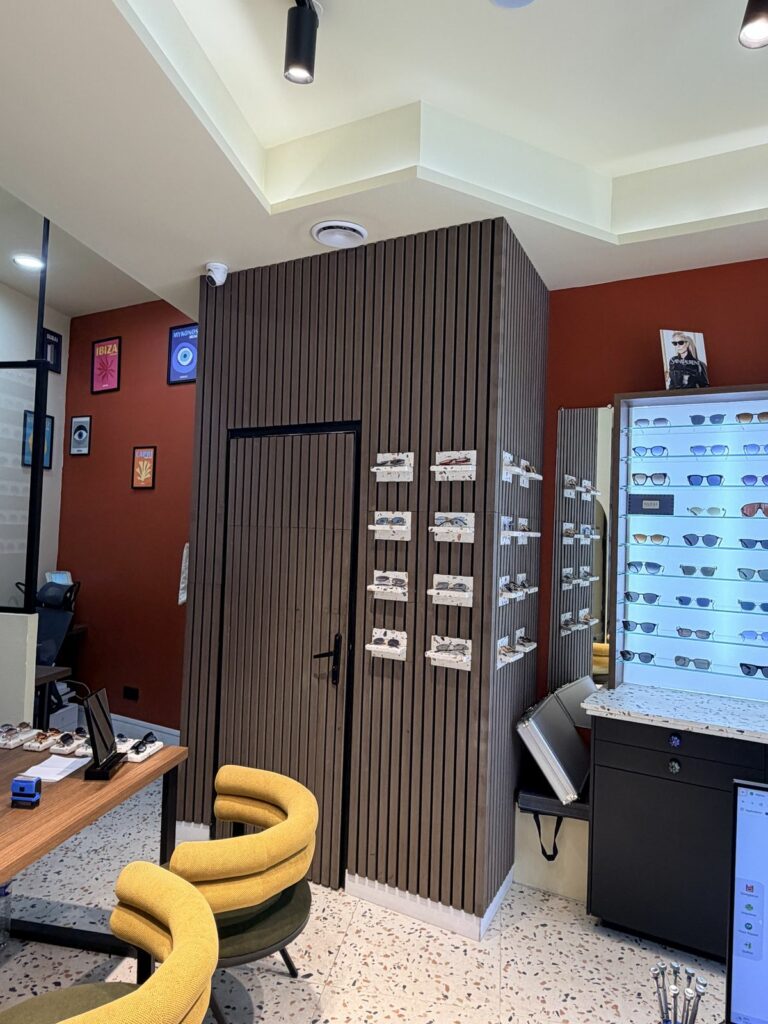 Boutique d’opticien après travaux à Paris 18e — Habillage à tasseaux bois et porte intégrée