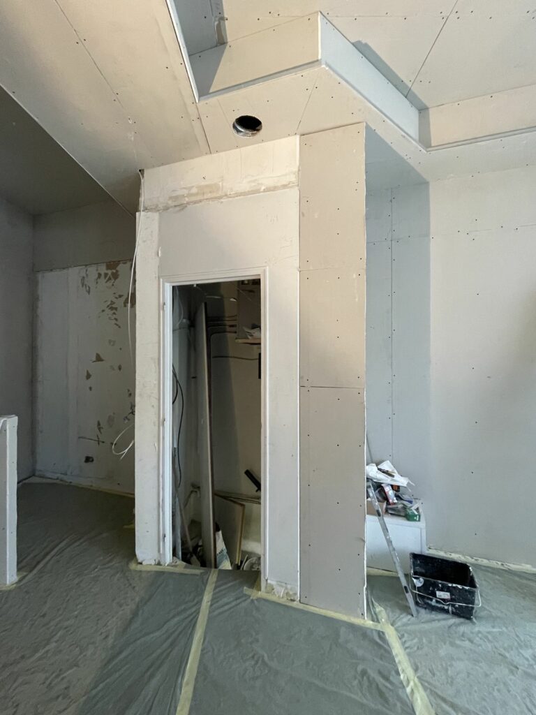Boutique d’opticien avant travaux à Paris 18e — Habillage à tasseaux bois et porte intégrée